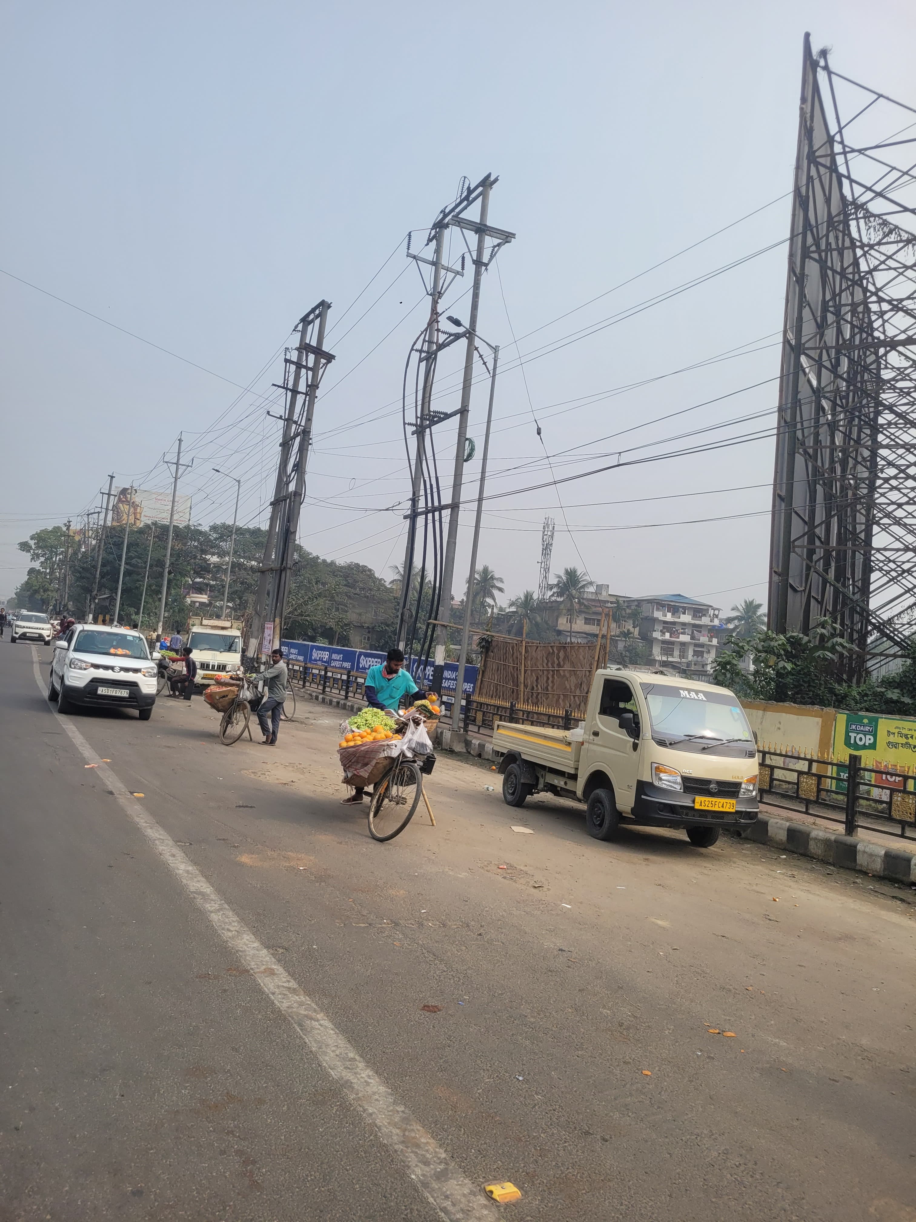 Guwahati's street vendors setting up shop on a busy road.